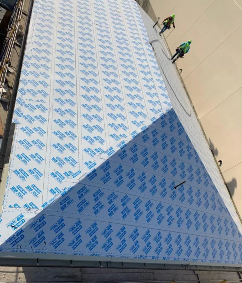 Professional roofers installing underlayment on a metal roof in Coon Rapids